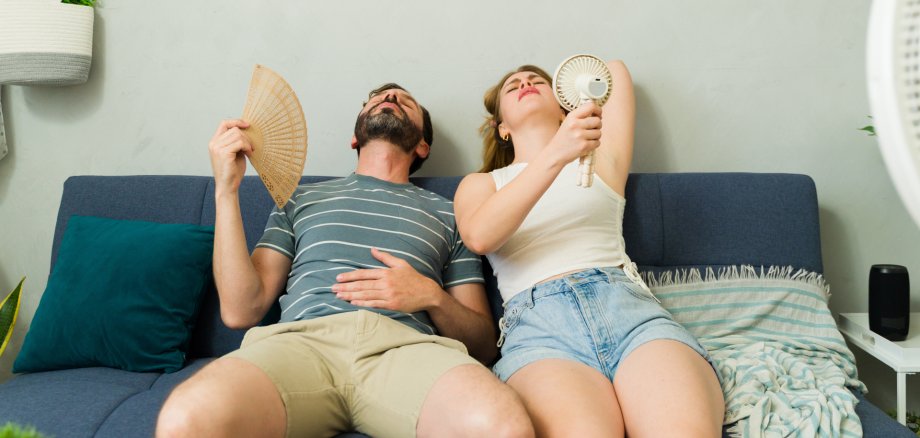 Overheated couple sweating at home during summer heat wave Overheated couple sweating at home during summer heat wave