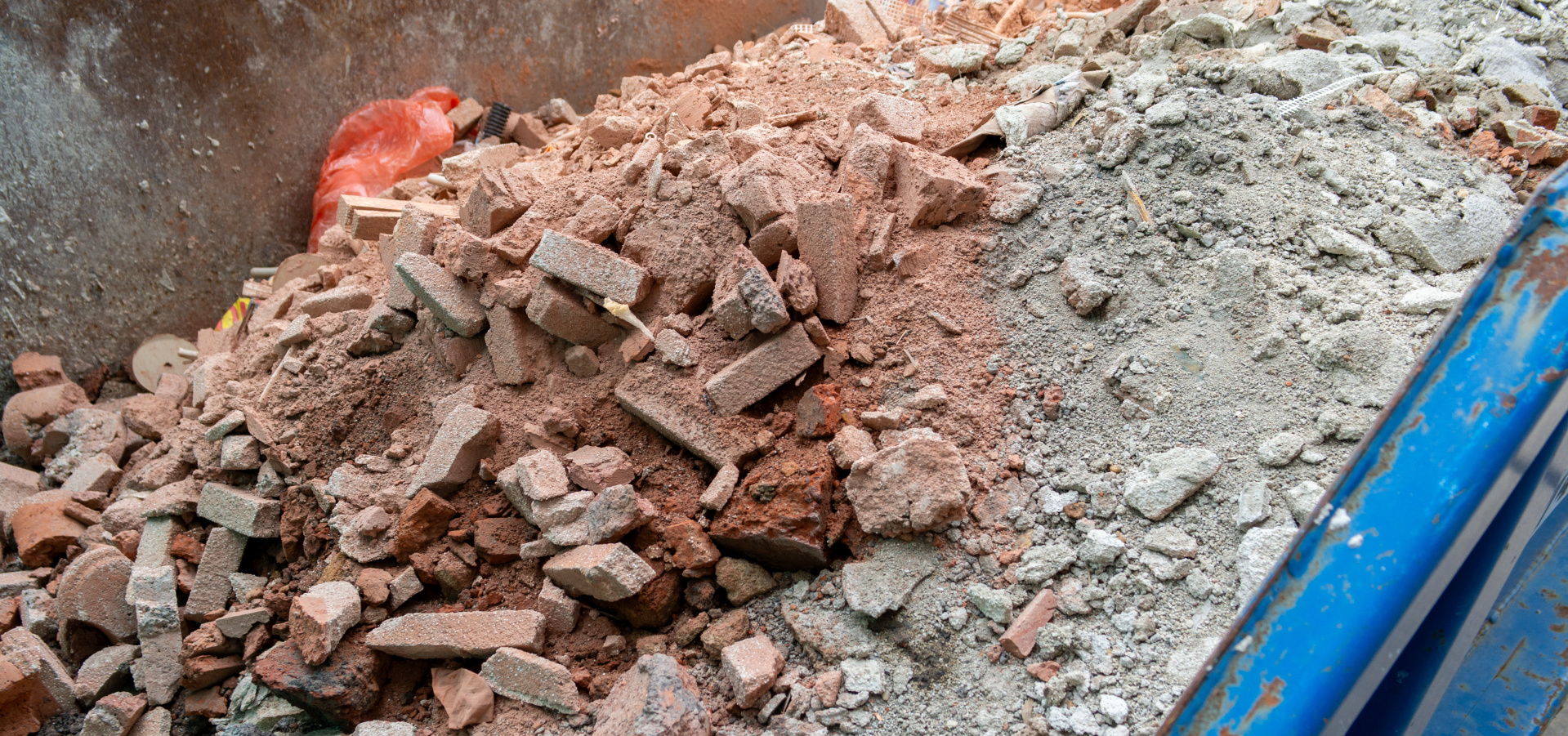 Blue container with construction debris on a construction site (panorama)