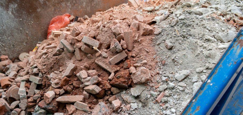 Blue container with construction debris on a construction site (panorama) Blue container with construction debris on a construction site (panorama)