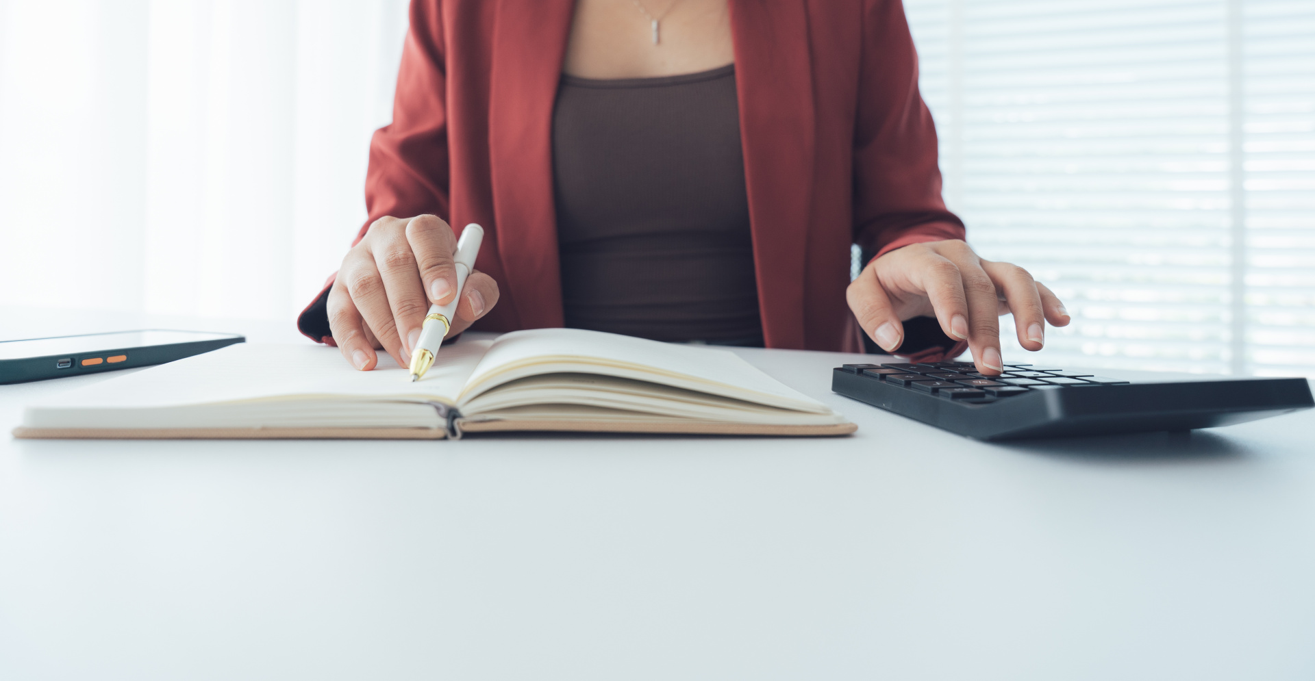 Busy Accountant: A sharp photo captures an accountant diligently focused on finances, with a calculator in one hand and a pen poised over a ledger in the other.